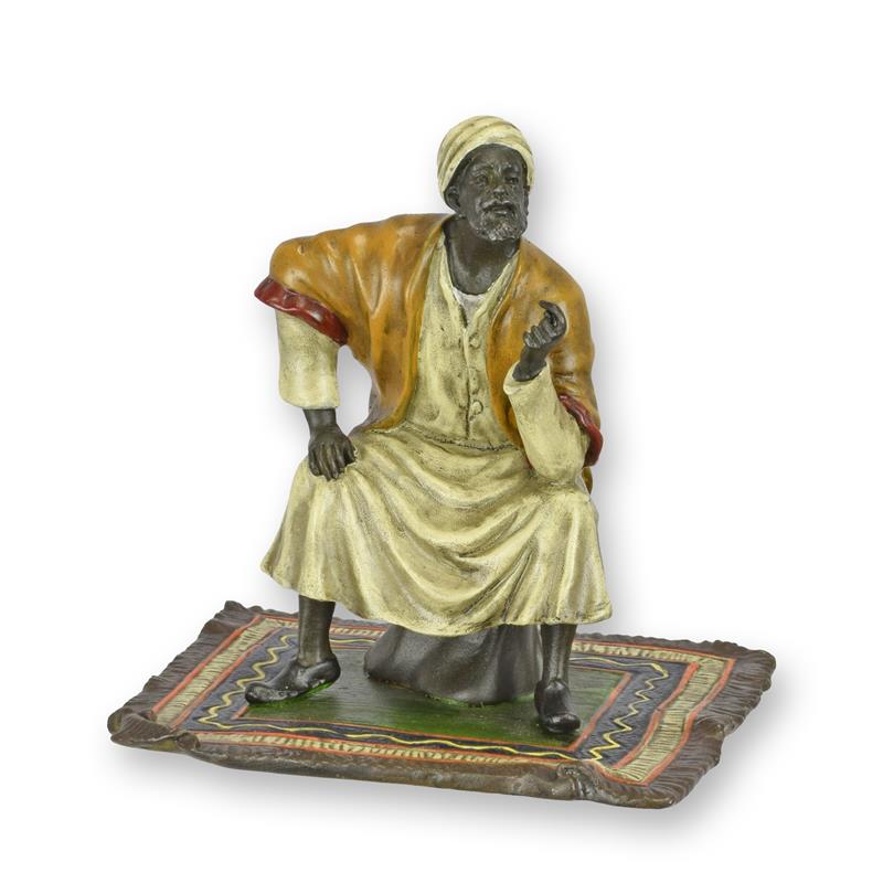 [LA-1822878] A BRONZE SCULPTURE OF AN ORIENTAL MERCHANT ON CARPET